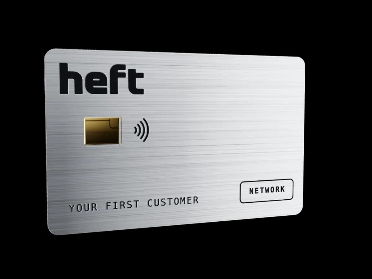 Brushed steel metal payment card with an engraved logo, gold chip and contactless symbol